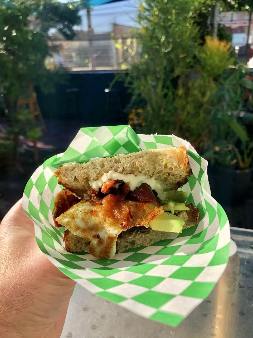 Breakfast sandwich with egg, bacon and avocado at Rise & Grind Cafe, a Coffee Shop in Los Angeles