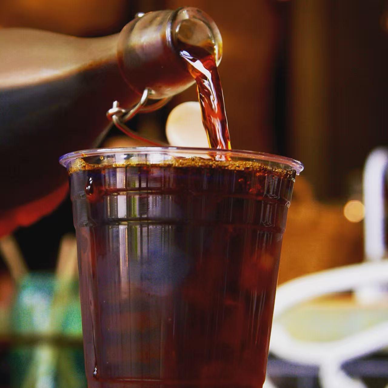 Cold brew coffee being poured into a clear cup at Rise & Grind Cafe, a Coffee Shop in Los Angeles