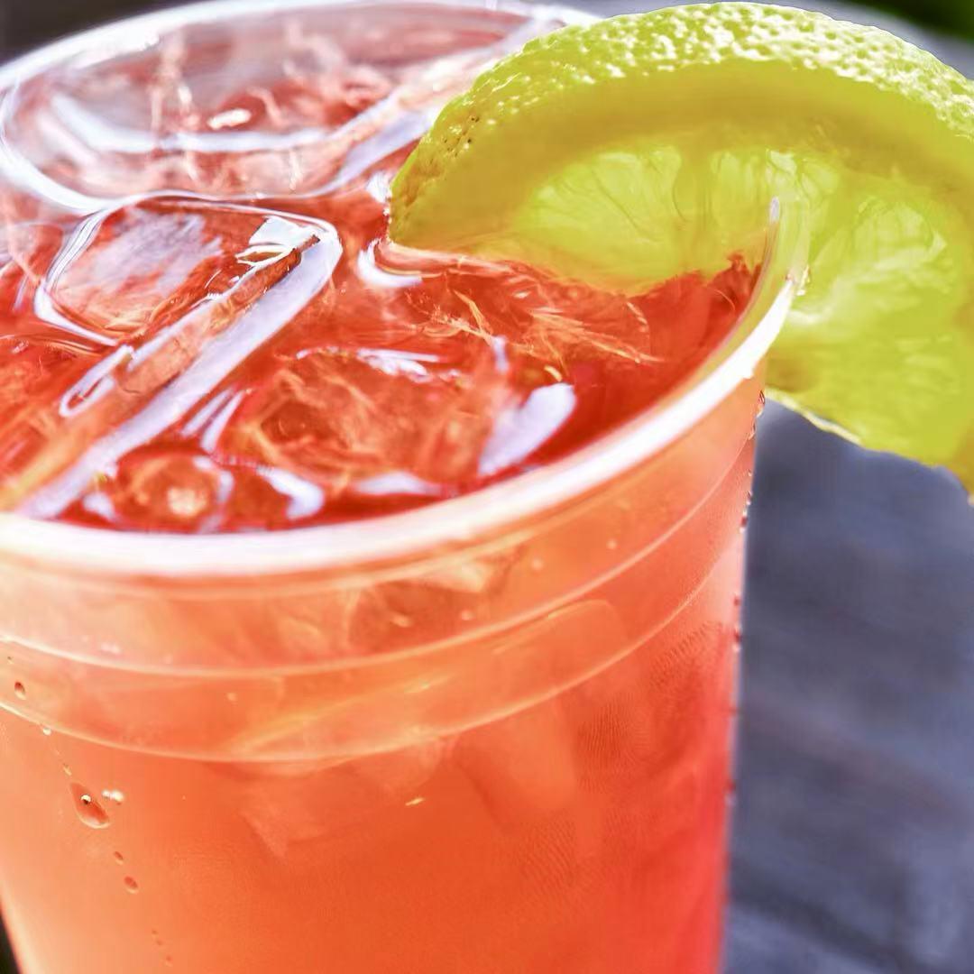 Pink grapefruit iced drink with a lime wedge at Rise & Grind Cafe, a Coffee Shop in Los Angeles