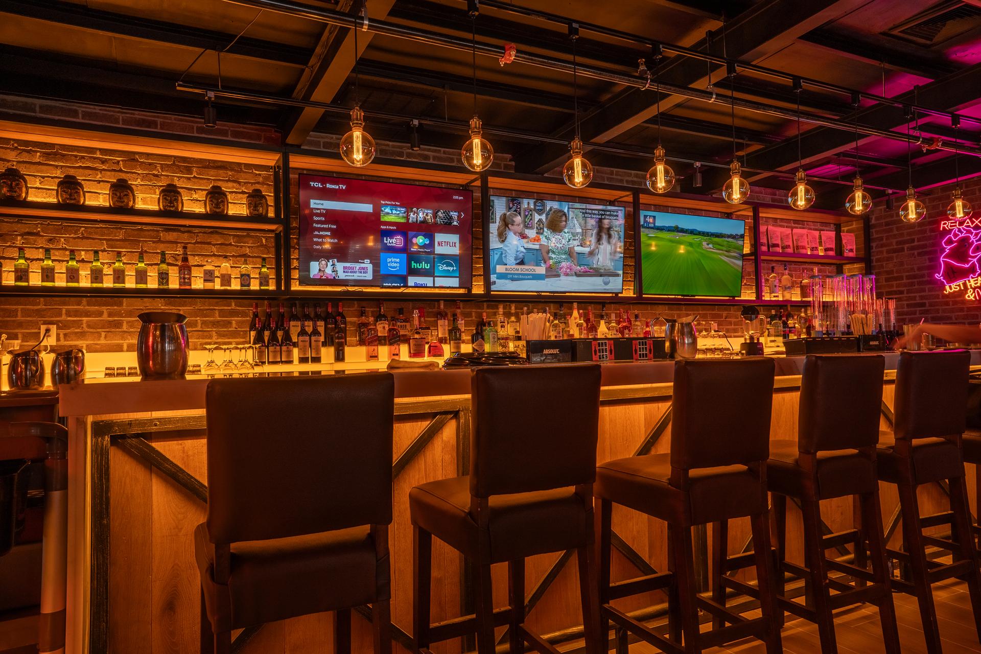 Modern Bar Area with Multiple TVs and Neon Signs
