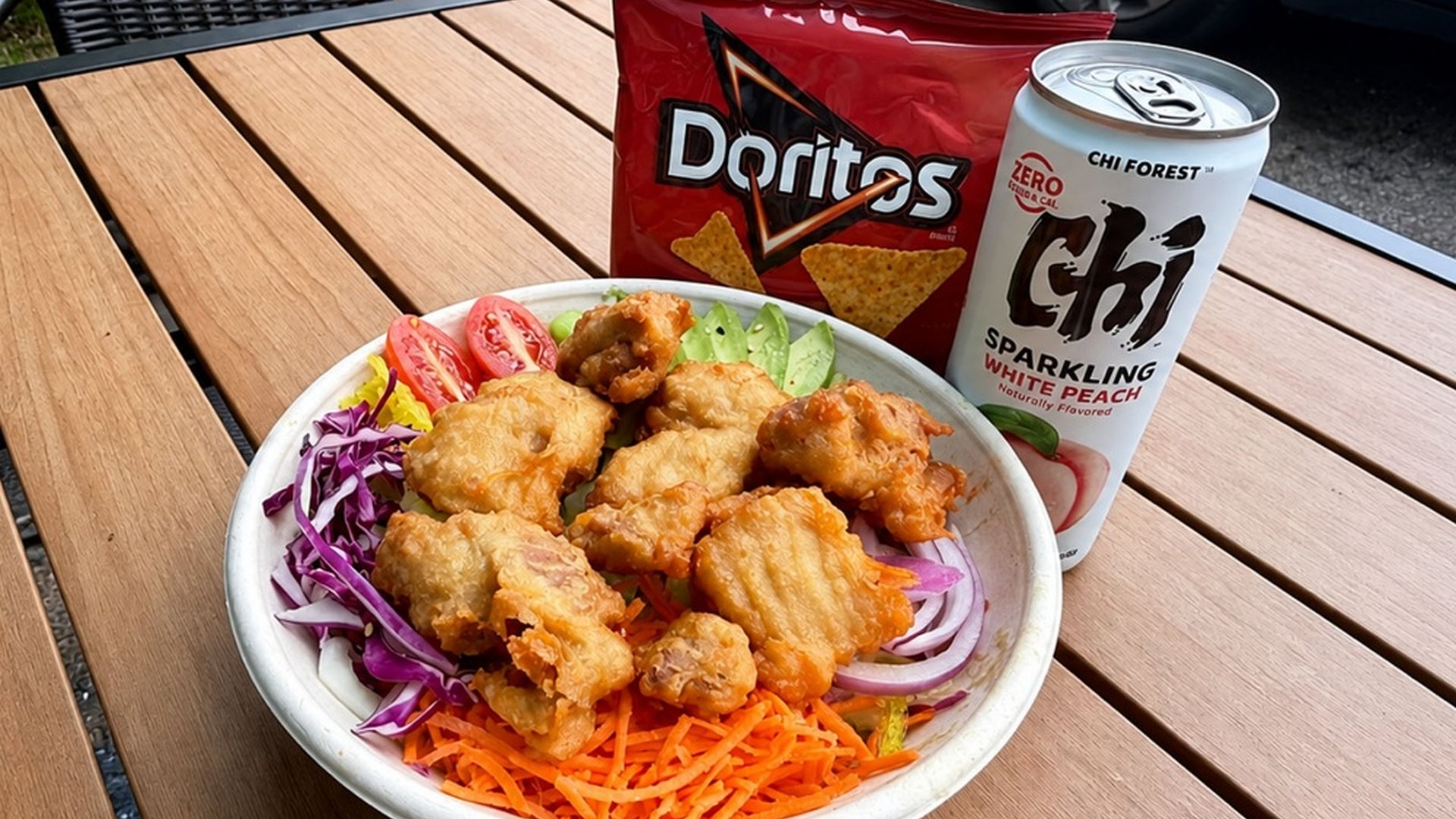 Fried chicken poke bowl with chips and peach sparkling drink at Sakana Western, a Hawaiian Restaurant in Chicago
