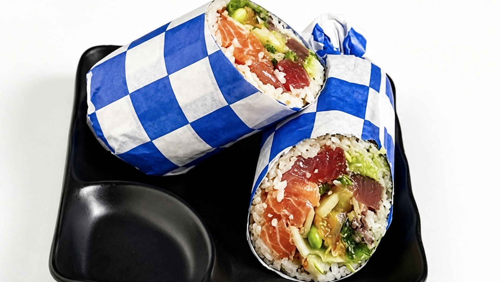 Raw fish sushi burrito wrapped in checkered paper at Sakana Western, a Hawaiian Restaurant in Chicago