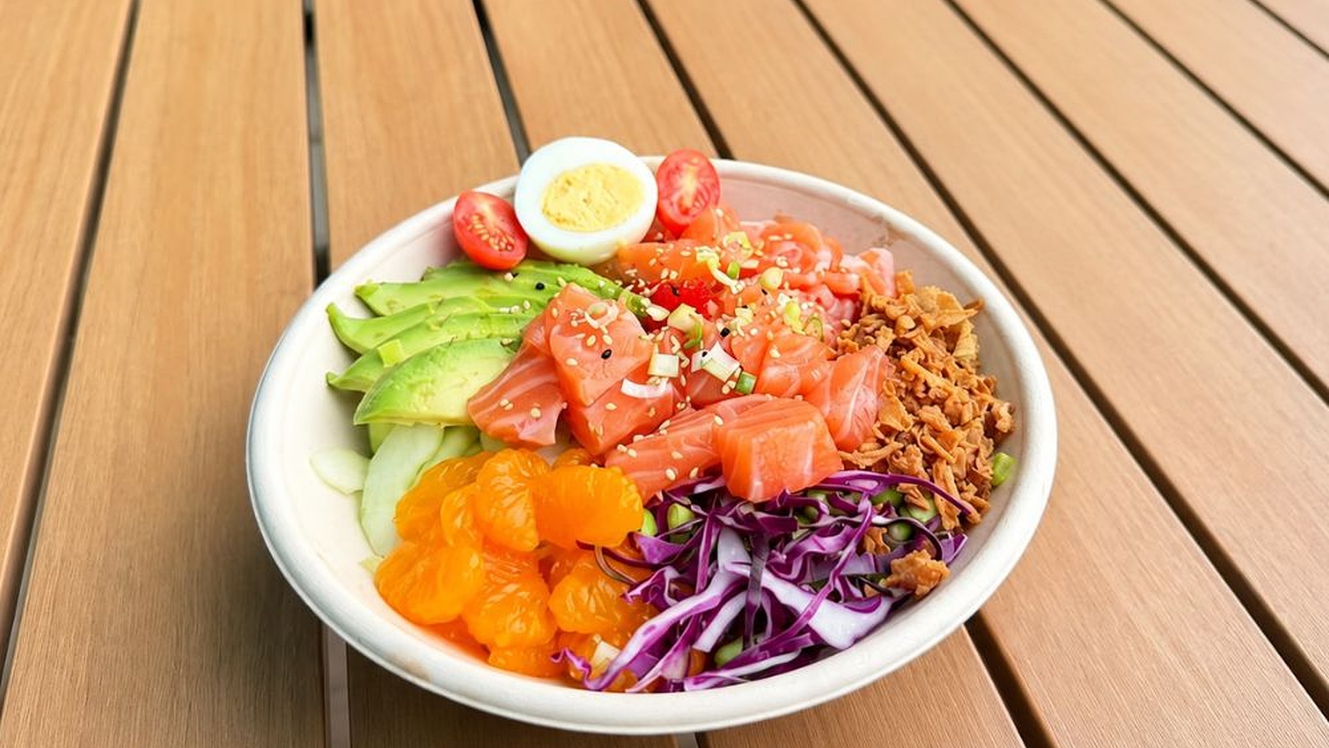 Salmon poke bowl with tangerine and avocado veggies at Sakana Western, a Hawaiian Restaurant in Chicago