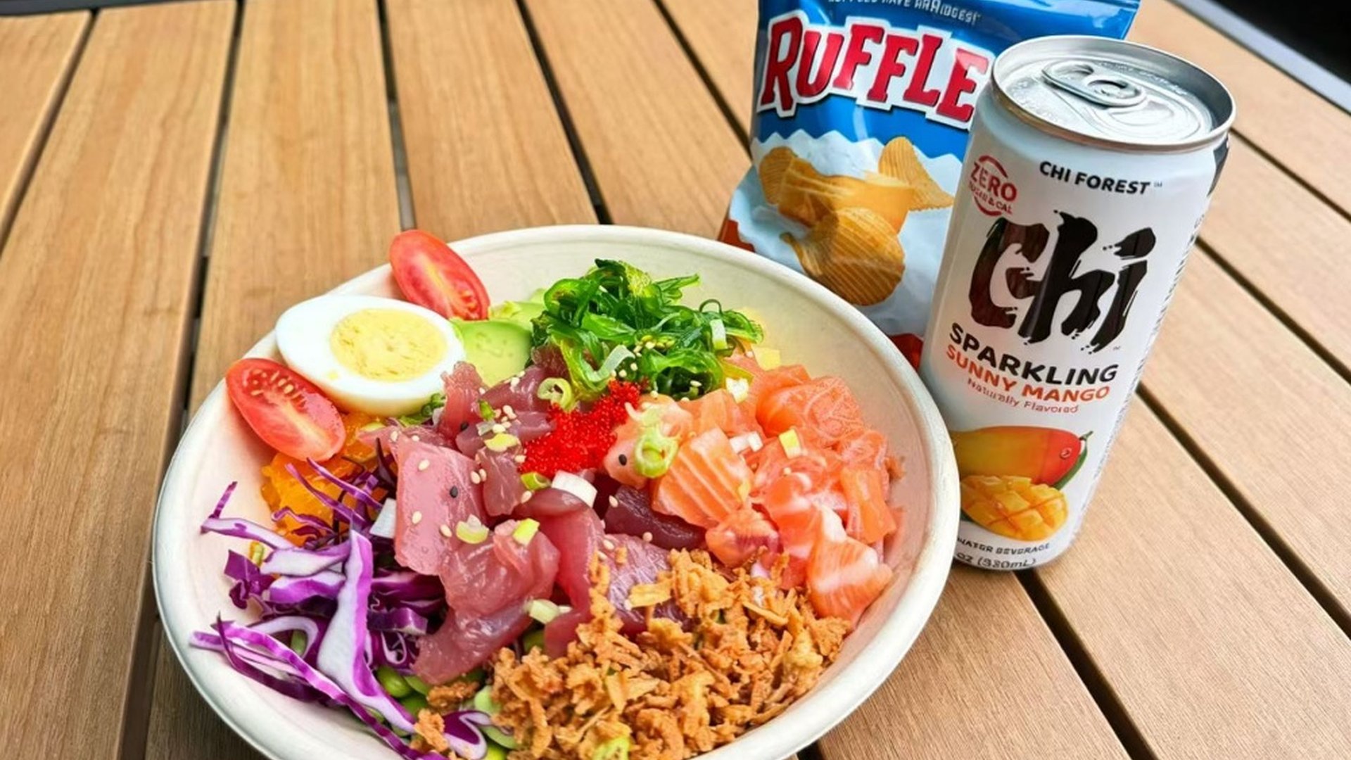 Seafood mix poke bowl with chips and mango sparkling drink at Sakana Western, a Hawaiian Restaurant in Chicago