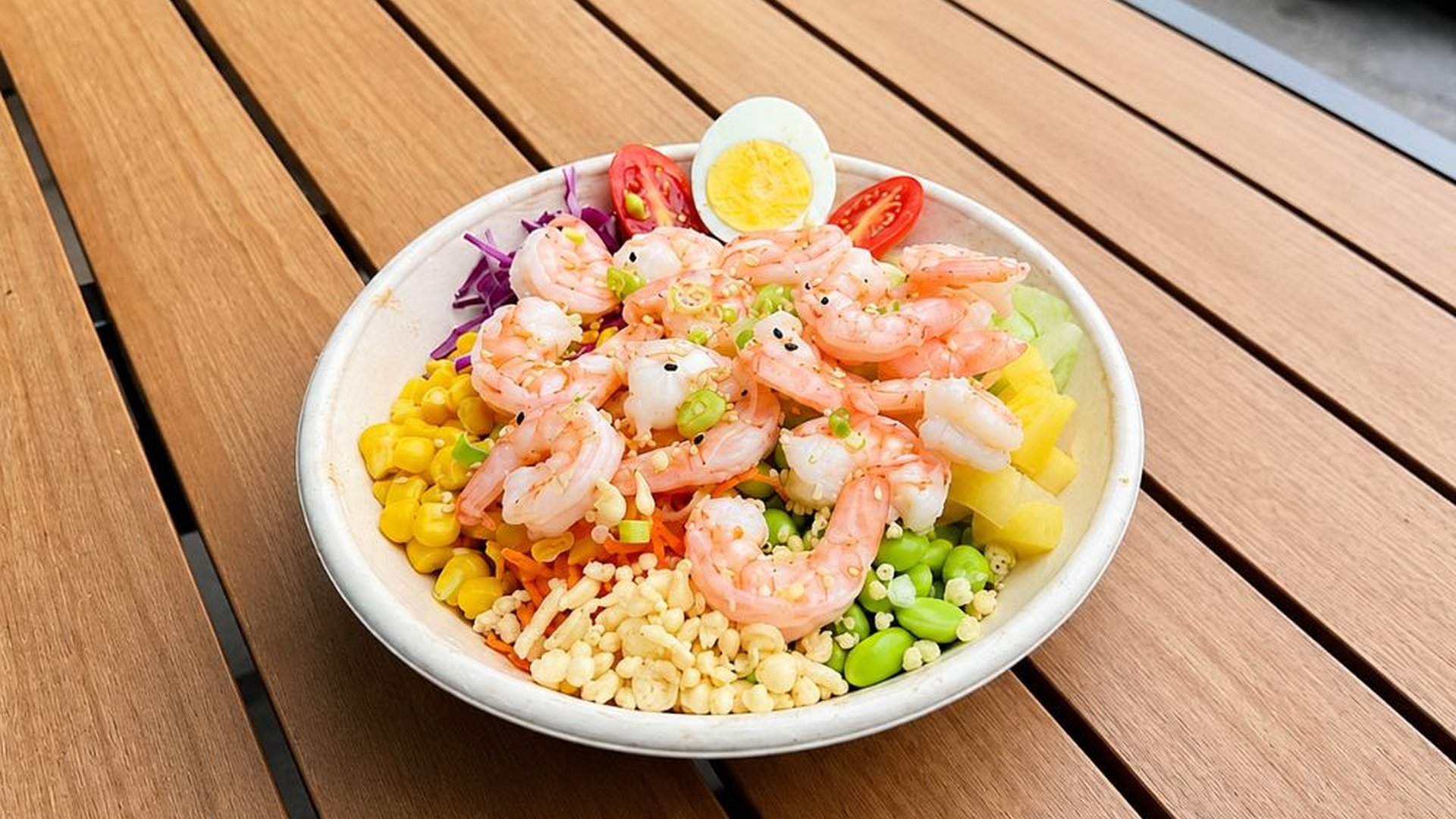 Shrimp poke bowl topped with various fresh side ingredients at Sakana Western, a Hawaiian Restaurant in Chicago