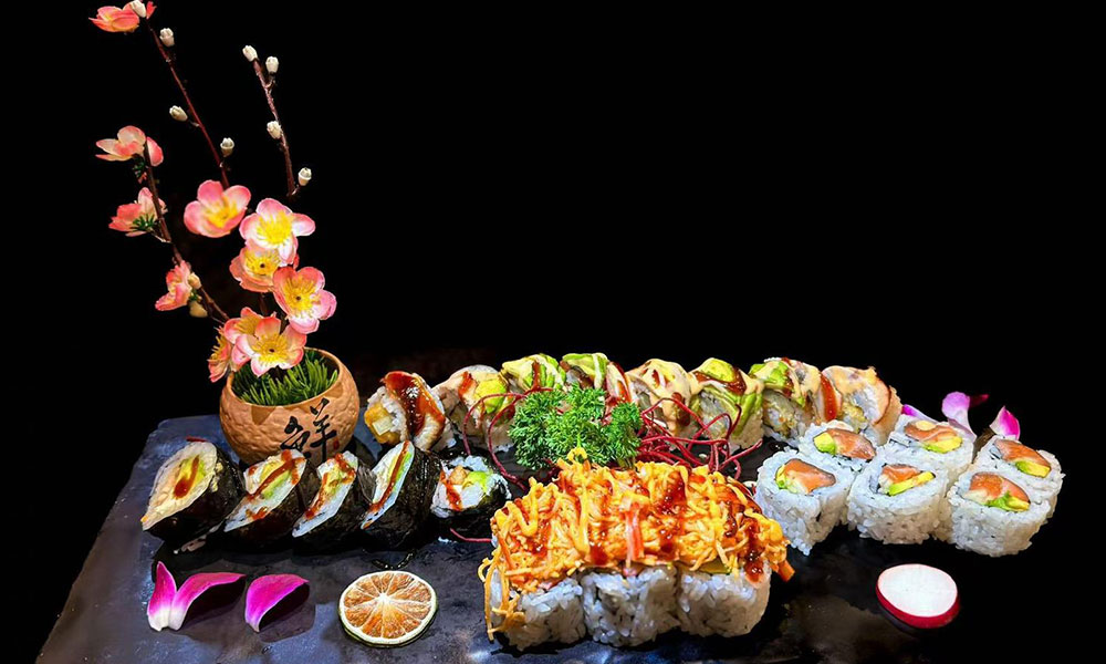 Mixed sushi roll assortment styled with plum blossom decor, citrus and shredded garnish at Saki, a Sushi Restaurant in Clear Water