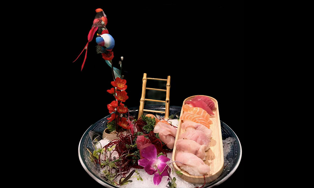 Premium mixed sashimi platter on ice with bamboo ladder and orchid decor at Saki, a Sushi Restaurant in Clear Water