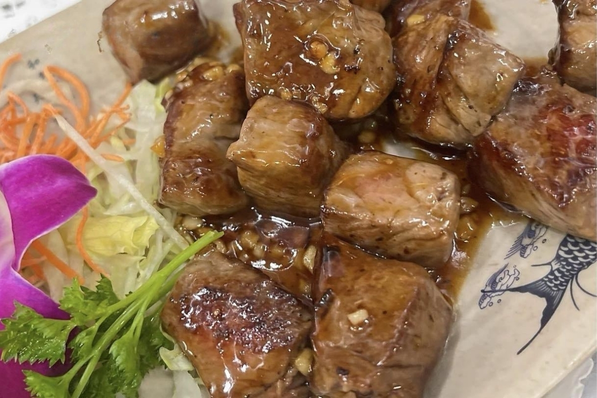 Glazed cubed steak garnished with shredded veggies and orchid at Sakura Sushi & Hibachi, a Japanese Restaurant in Kapolei