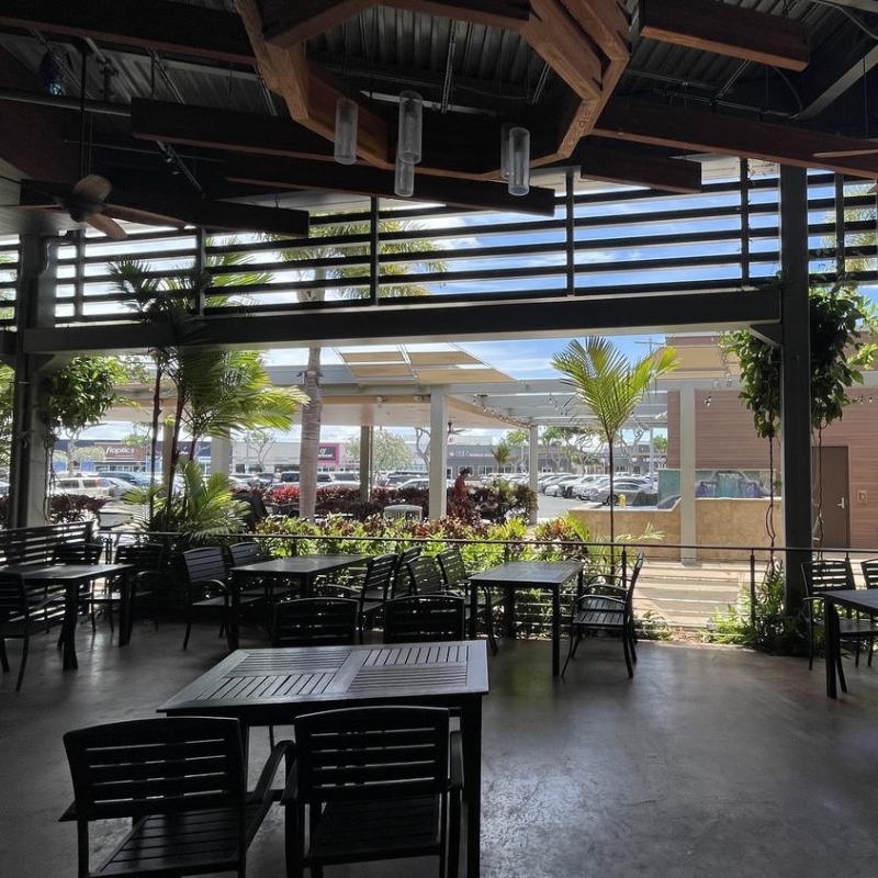 Open-air outdoor seating overlooking parking lot greenery at Sakura Sushi & Hibachi, a Japanese Restaurant in Kapolei