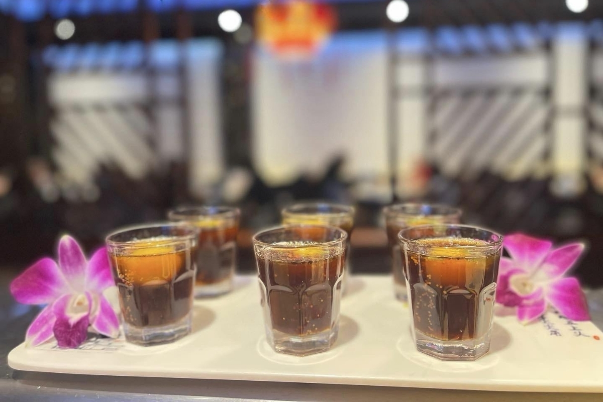 Set of layered shot drinks decorated with purple orchids at Sakura Sushi & Hibachi, a Japanese Restaurant in Kapolei