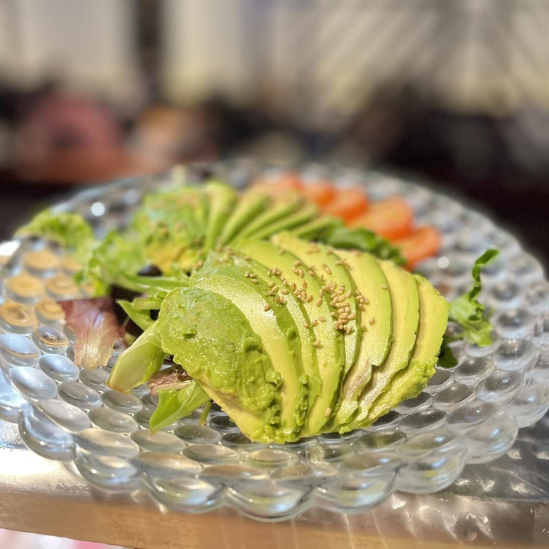Sliced avocado salad topped with sesame seeds on glass plate at Sakura Sushi & Hibachi, a Japanese Restaurant in Kapolei