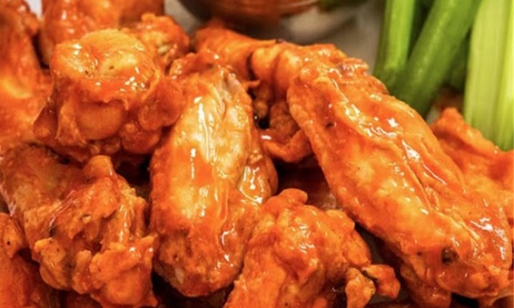 Glossy buffalo chicken wings with celery at Crab Seafood House-Sanford, a Seafood Restaurant in Sanford