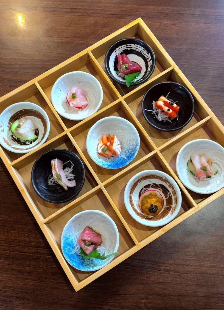 Assorted sashimi in a wooden compartment tray at Sapporo Izakaya, a Japanese Restaurant in The Woodlands