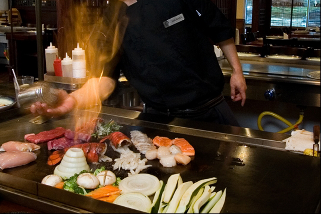 Chef cooking assorted meats and veggies on a hibachi grill at Sasa, a Japanese Restaurant in Farmingdale.