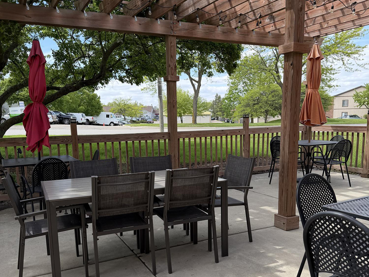Outdoor patio with tables under a wooden pergola at Savory Bun, a Chinese Restaurant in Roselle