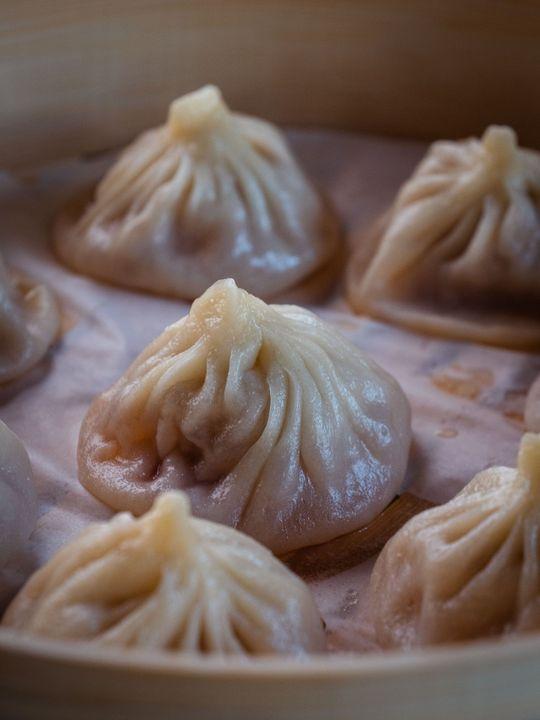 Steamed soup dumplings served in a bamboo basket at Savory Bun, a Chinese Restaurant in Roselle