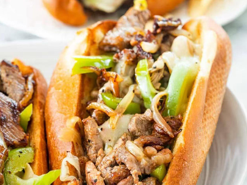 Philly cheesesteak sandwich loaded with grilled beef, green peppers, onions and melted cheese at Seafood&wings, a Seafood Restaurant in Greenville