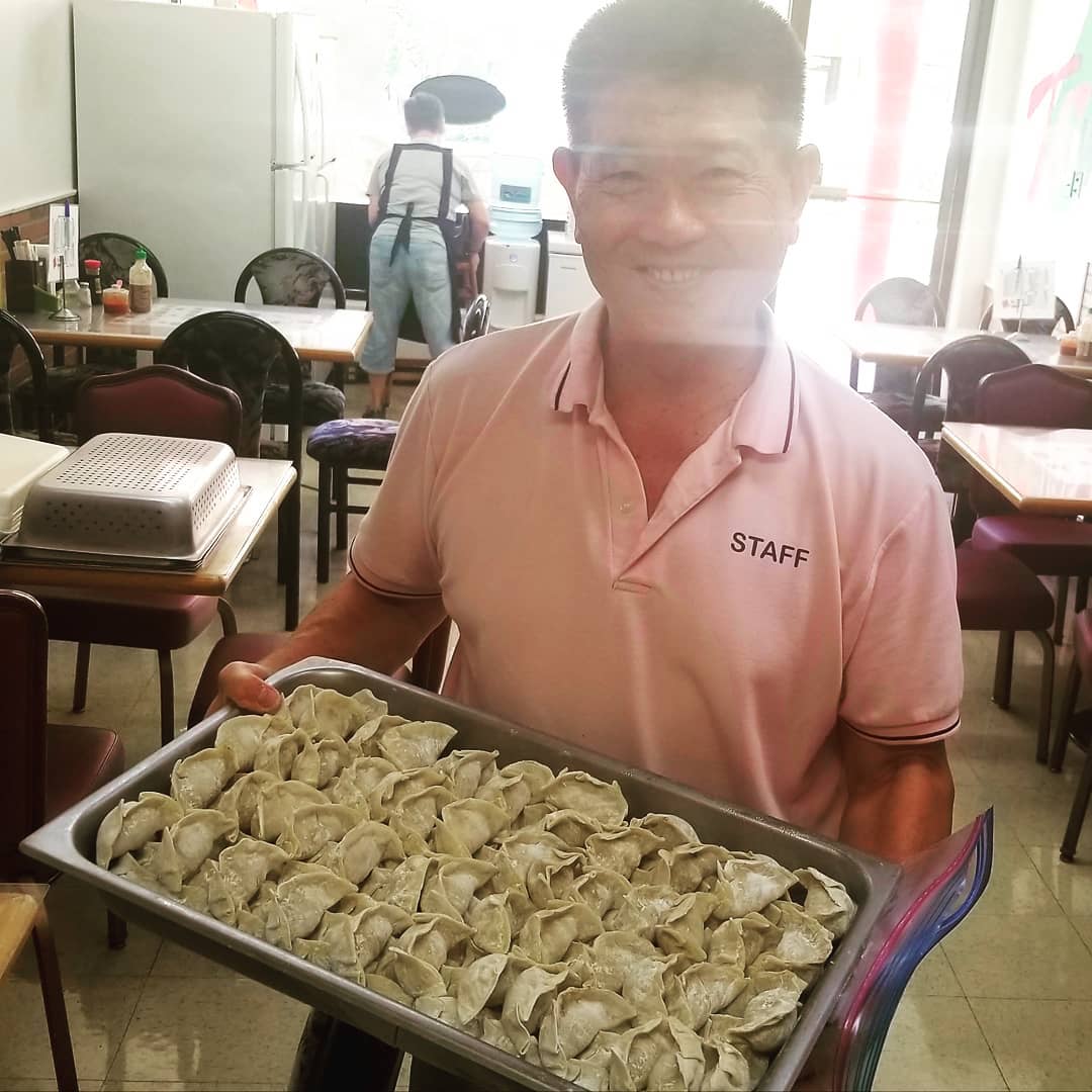 Staff member holding tray of uncooked dumplings at Seasons Taiwanese Eatery，a Taiwanese Restaurant in Honolulu
