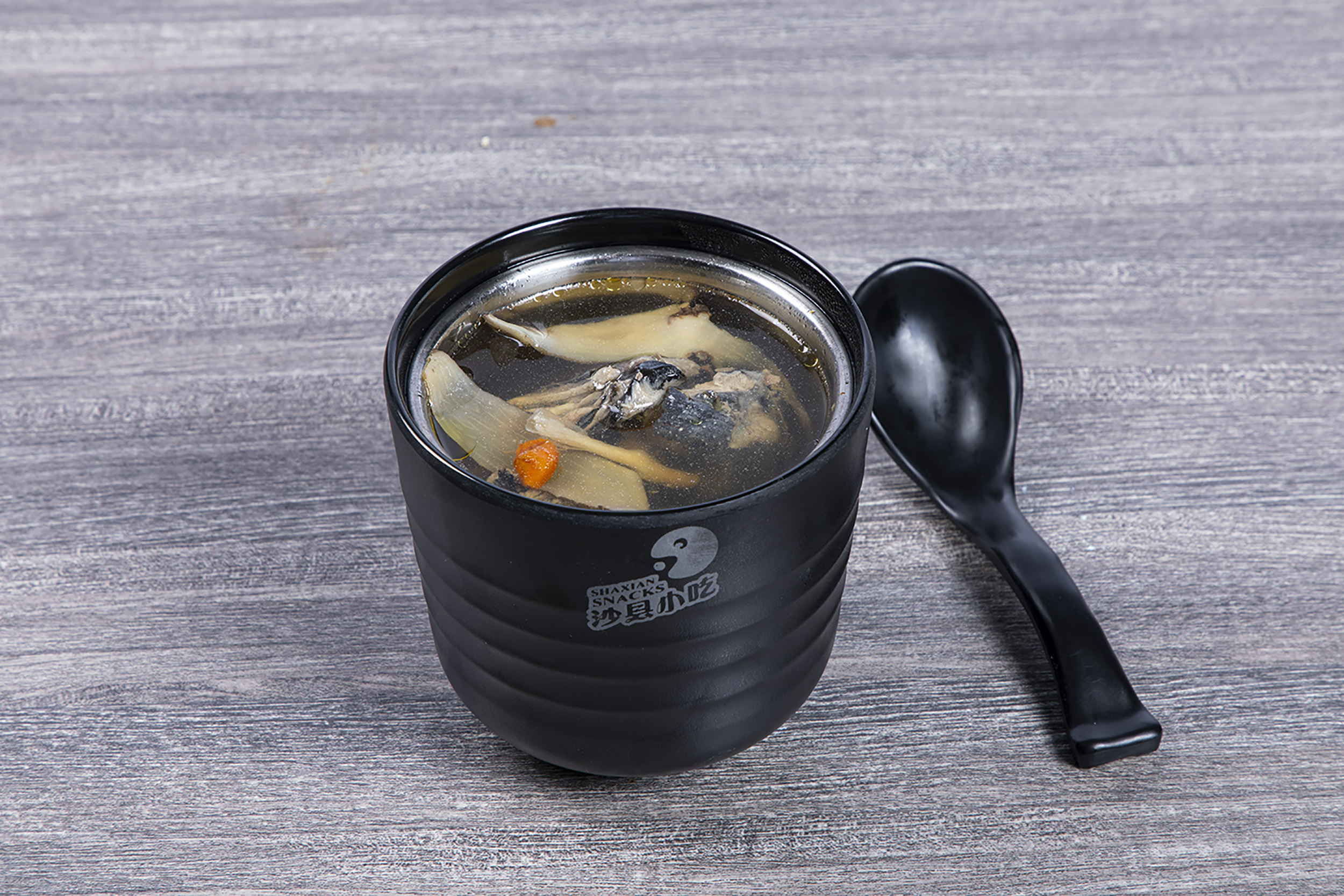Slow-cooked black bone chicken herbal soup in ceramic cup at Shaxian Snacks, a Chinese Restaurant in Elmhurst