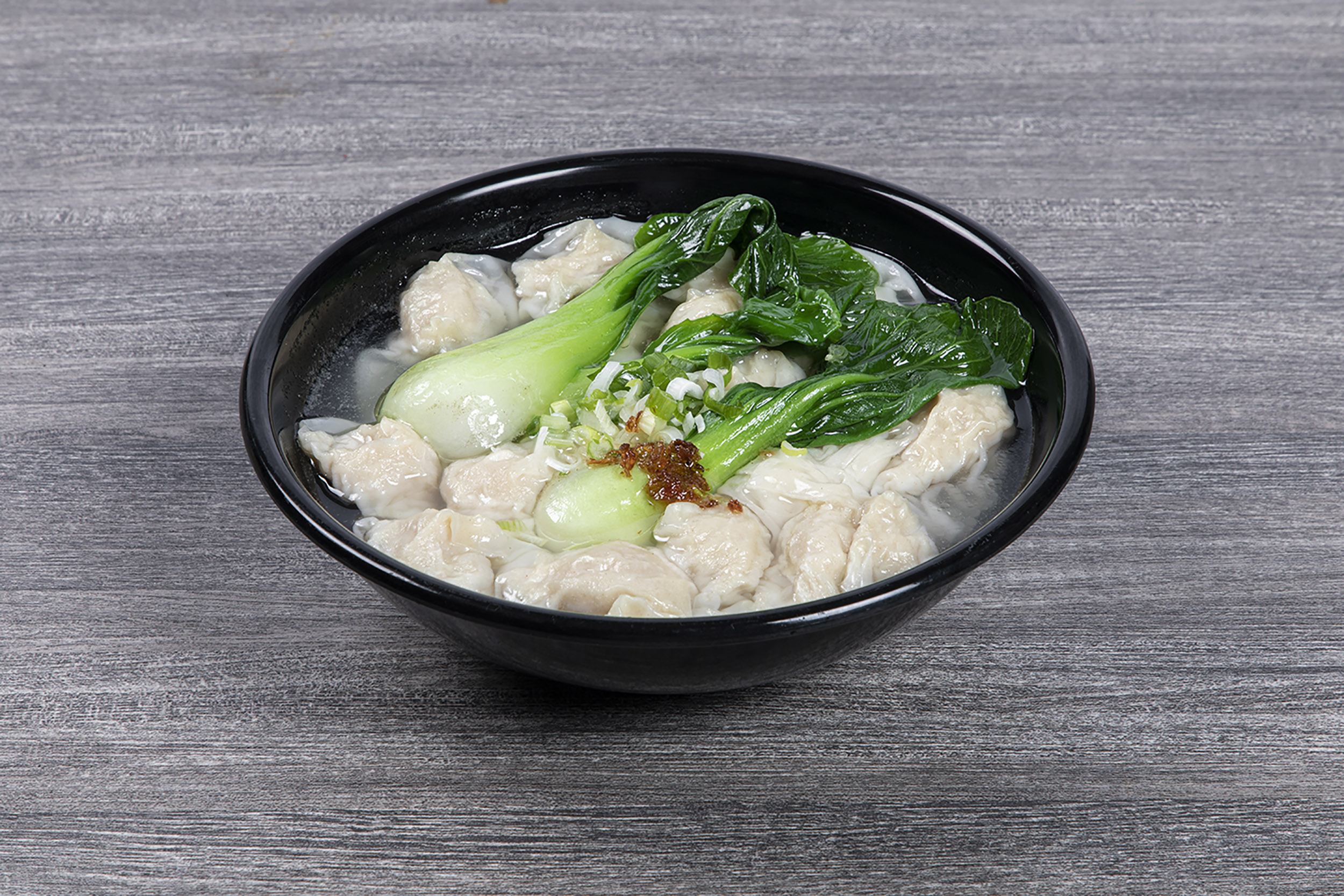 Soup wontons paired with bok choy and crispy shallot oil at Shaxian Snacks, a Chinese Restaurant in Elmhurst