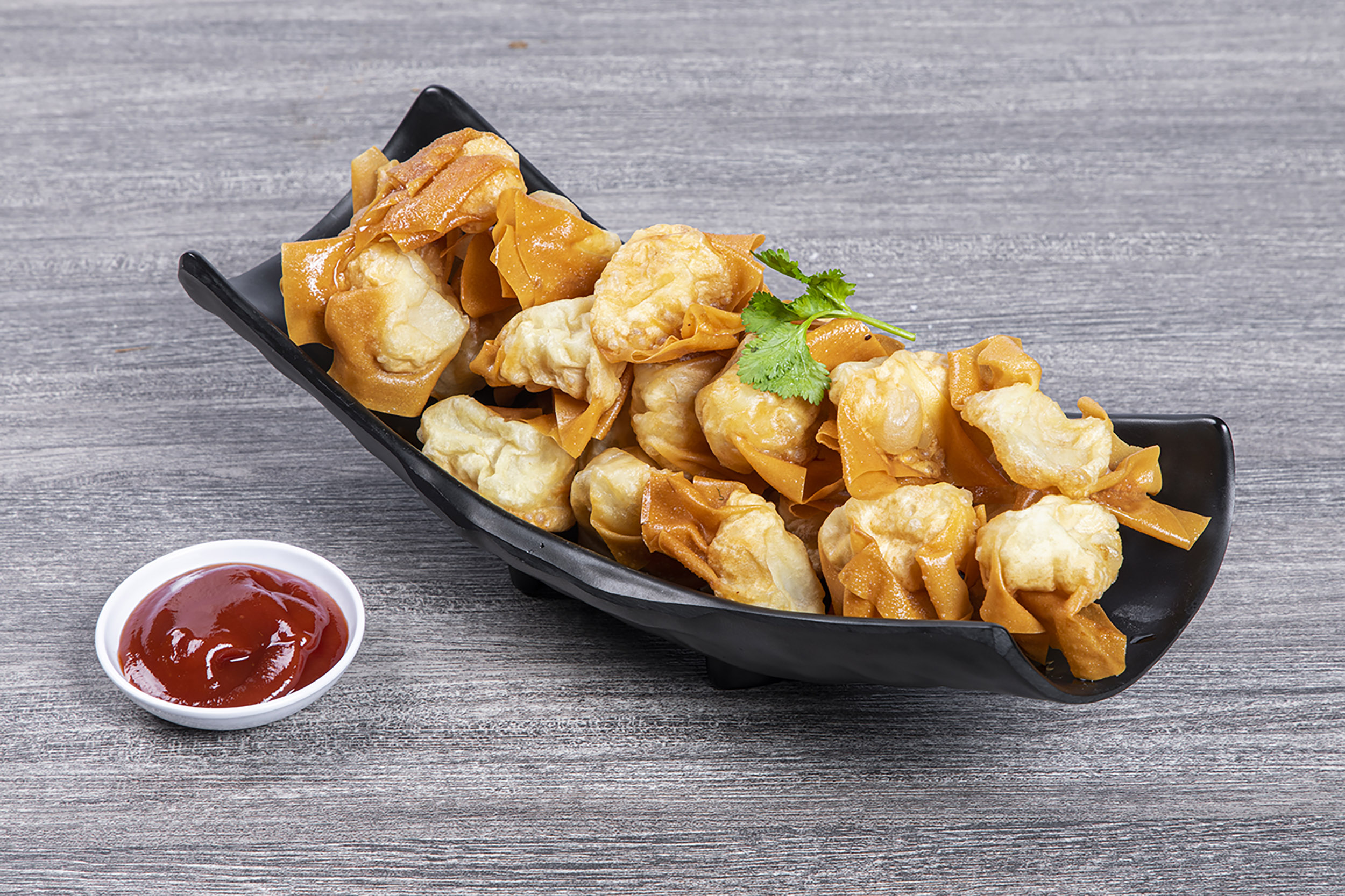 Crispy fried wontons served with side tomato dipping sauce at Shaxian Snacks, a Chinese Restaurant in Elmhurst