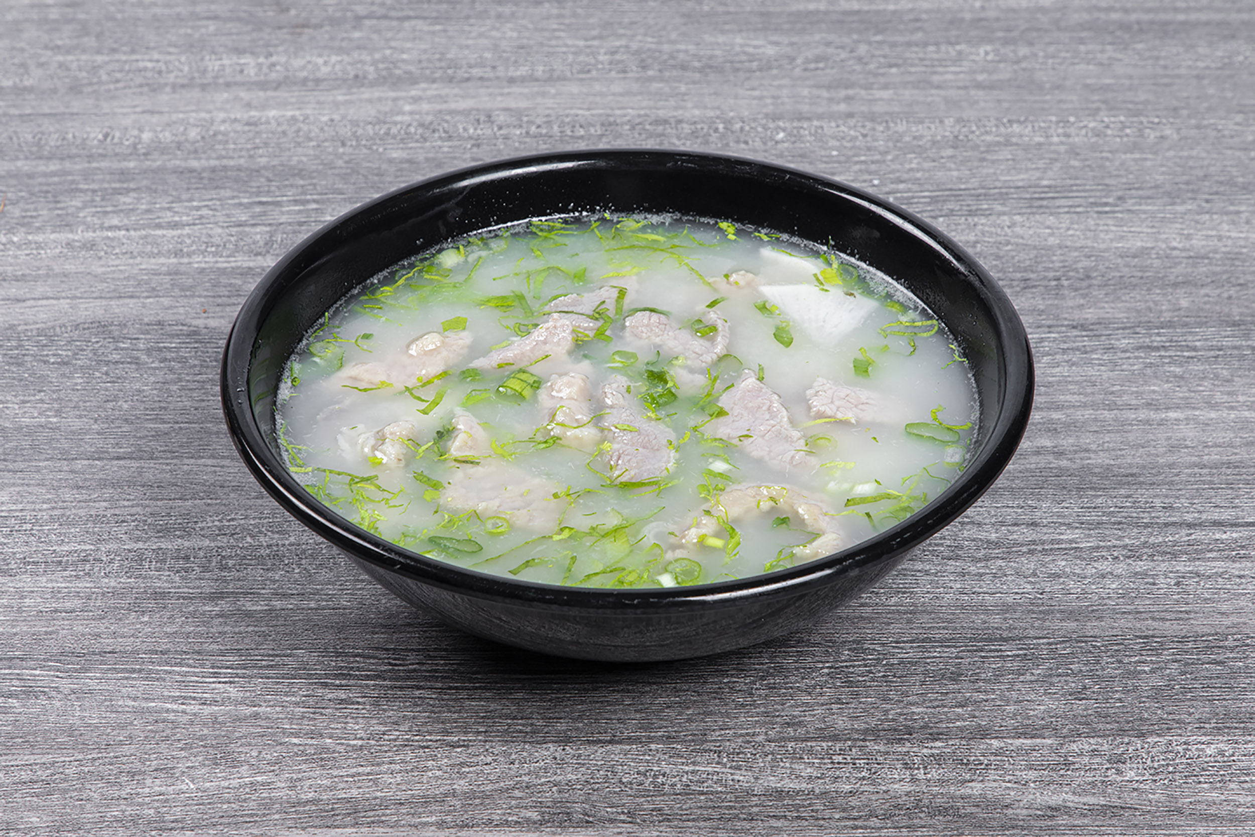 Clear lean pork soup garnished with shredded green scallion at Shaxian Snacks, a Chinese Restaurant in Elmhurst