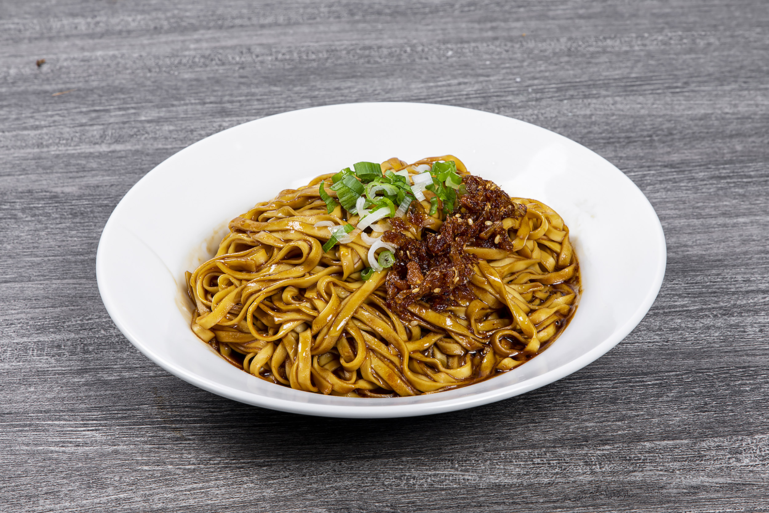 Scallion oil wide noodle topped with crispy fried shallot at Shaxian Snacks, a Chinese Restaurant in Elmhurst