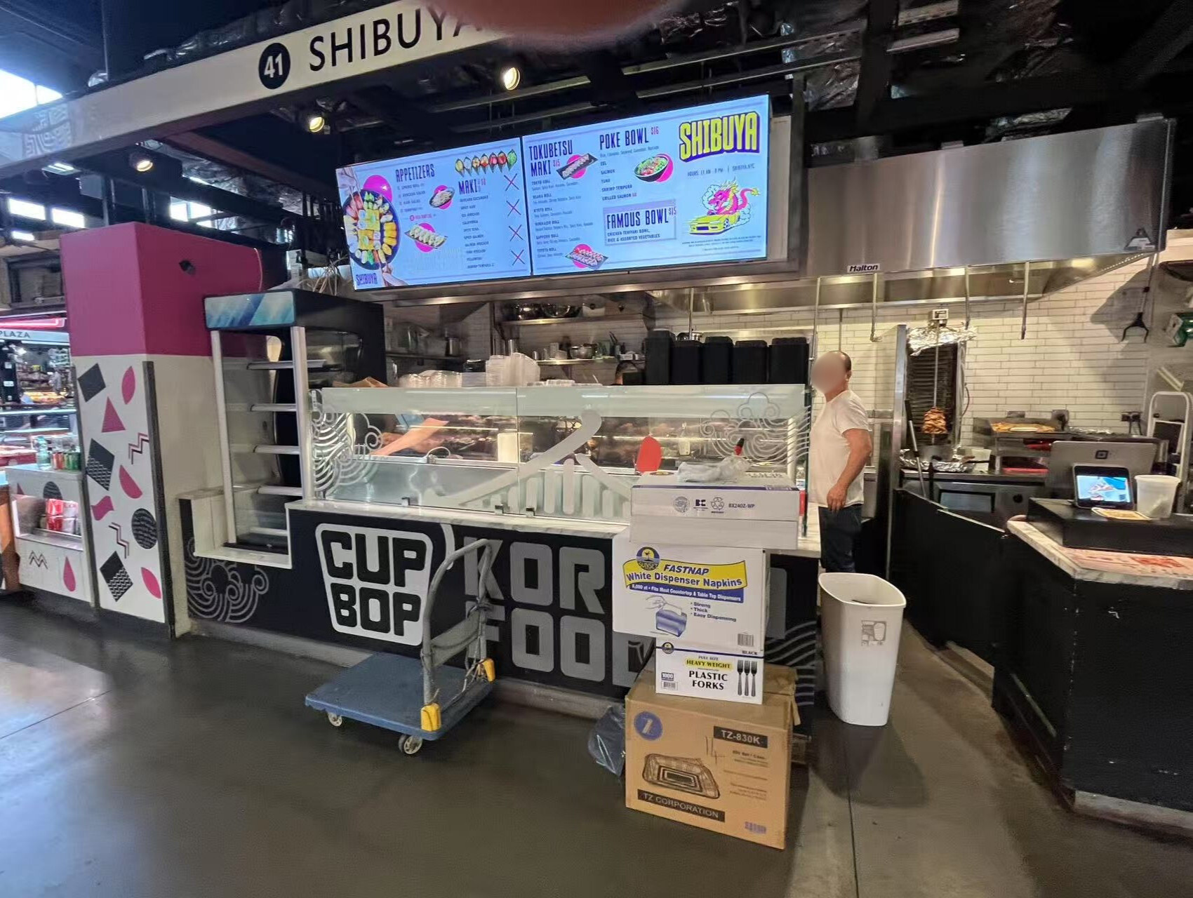 Shibuya counter area with staff and stacked supplies.