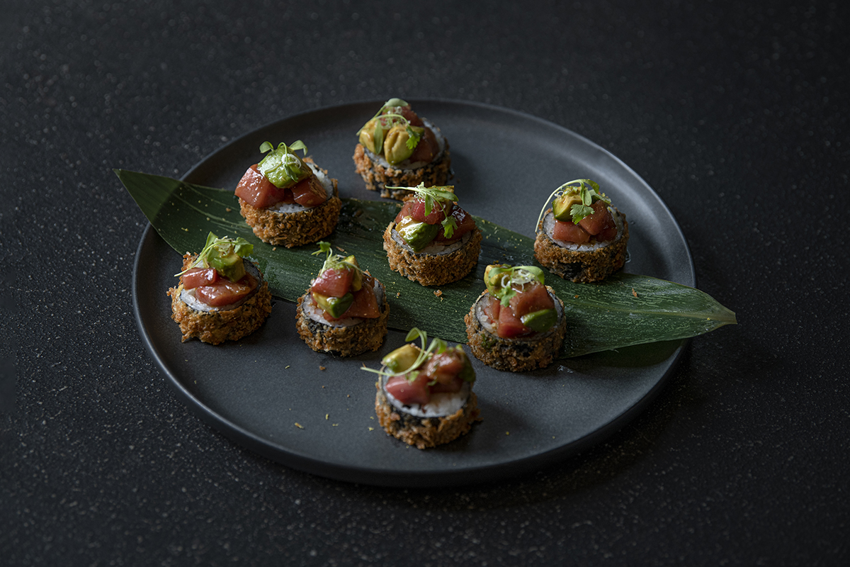Crunchy sushi rolls topped with tuna and avocado, on a dark plate at Shiki Sushi，a Japanese Restaurant in Santa Rosa