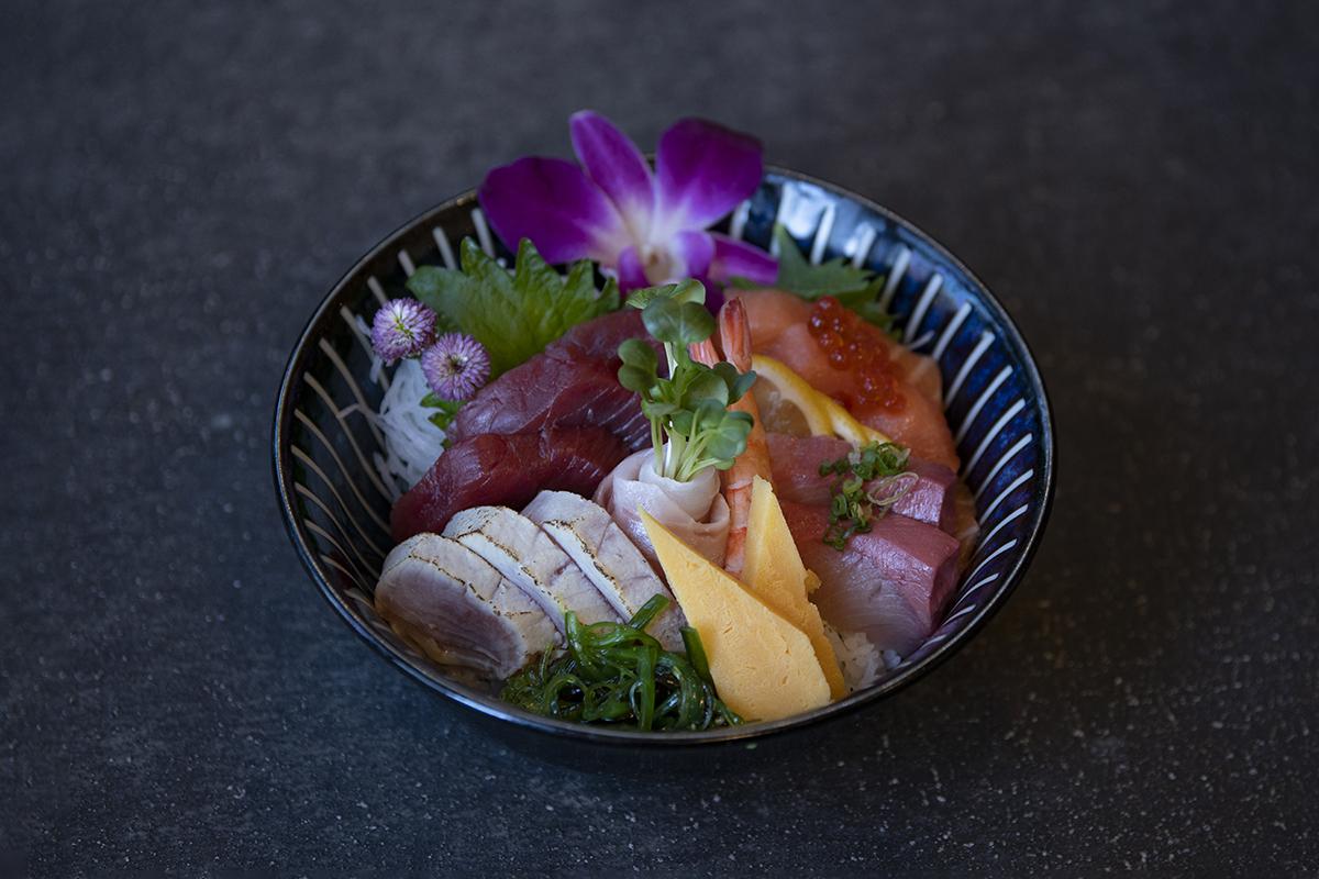 Bowl of sashimi (tuna, shrimp) with rice, garnished with flowers and greens at Shiki Sushi，a Japanese Restaurant in Santa Rosa