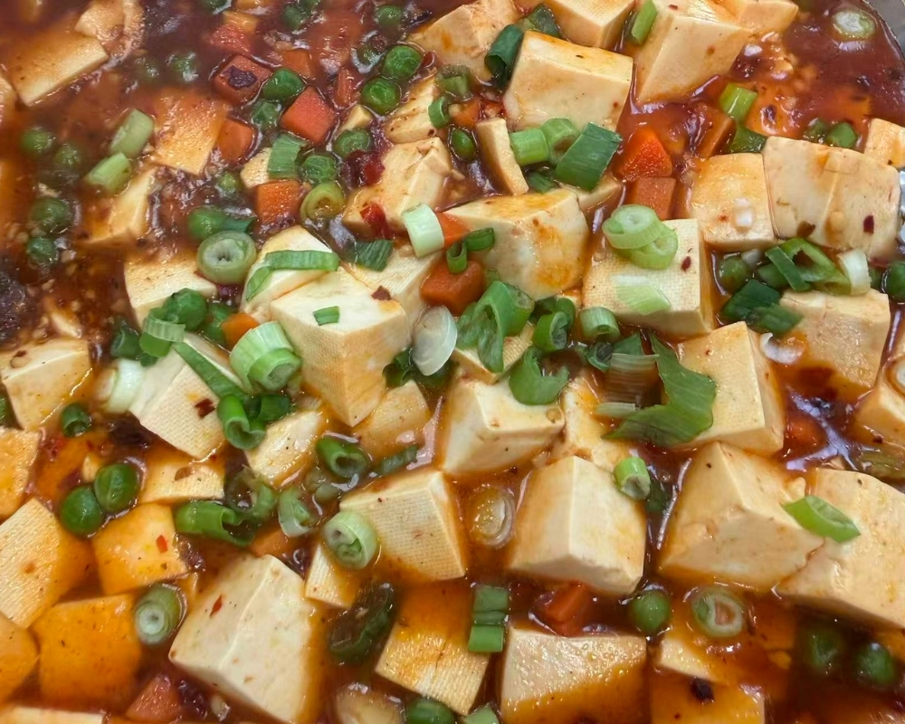 Spicy mapo tofu with peas and chopped green onions at Siu Lap City, a Chinese Restaurant in Houston