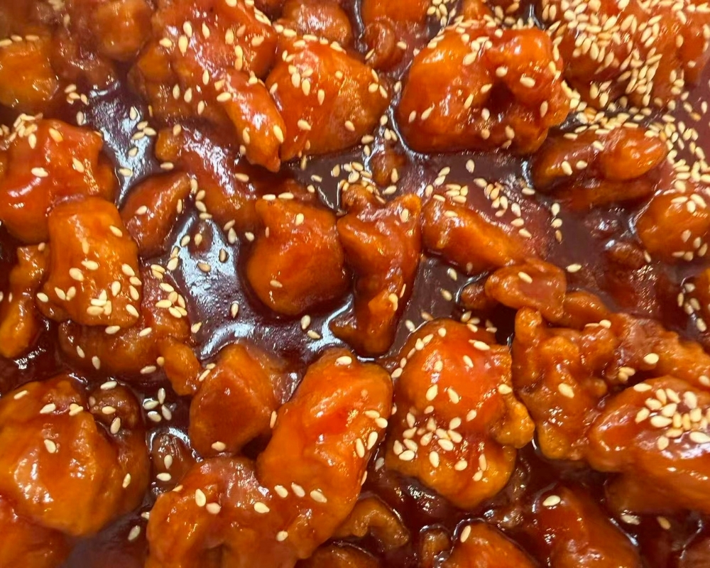 Sweet sour chicken chunks topped with white sesame at Siu Lap City, a Chinese Restaurant in Houston