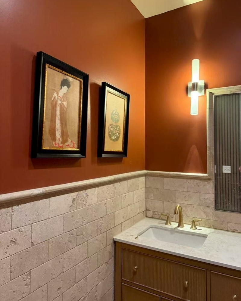 Stylish restroom with terracotta walls and Asian art at SOHO Asian Fusion, a Asian Fusion Restaurant in Austin.