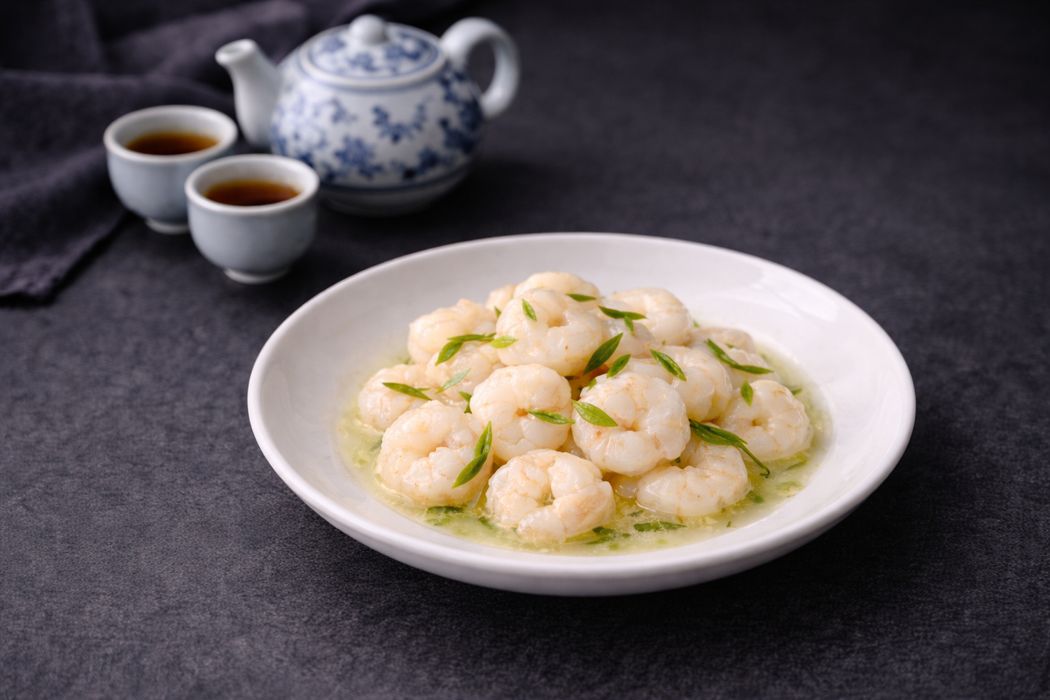 `Stir-fried shrimp with green herbs in a white bowl, served with tea set`