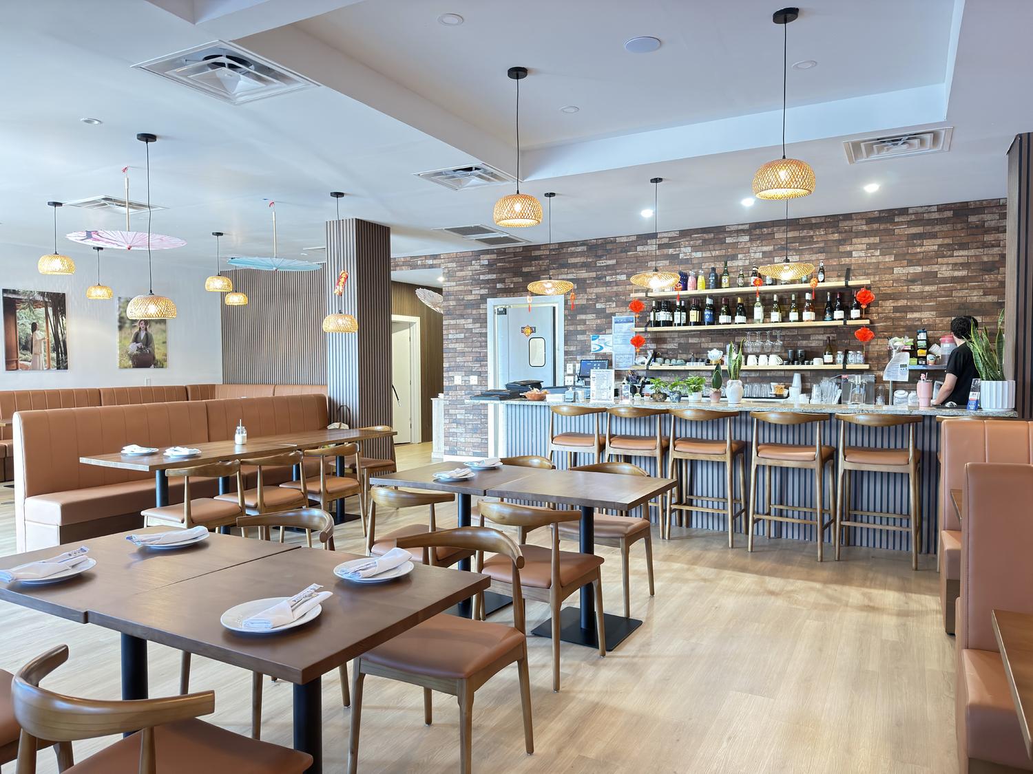 Bright restaurant dining area with wooden tables, bar seating, and exposed brick wall at SoHo Asian Fusion, a Asian fusion restaurant in Austin