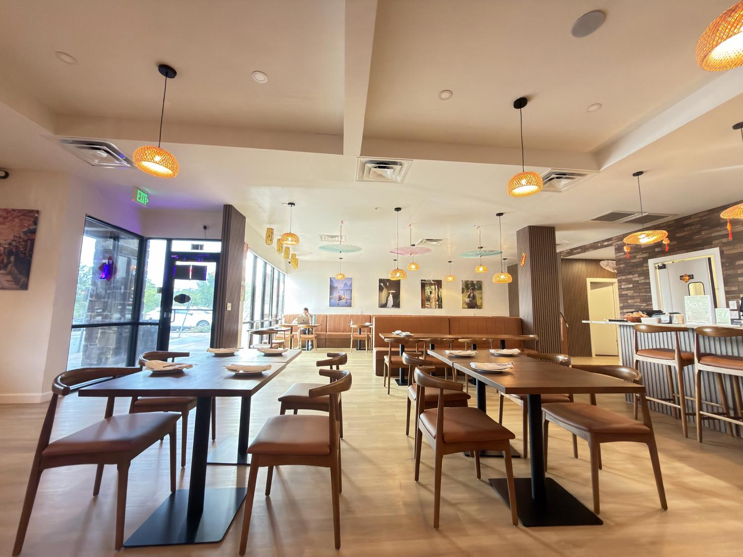 Bright restaurant interior with large windows, wooden tables, and woven pendant lights at SoHo Asian Fusion, a Asian fusion restaurant in Austin