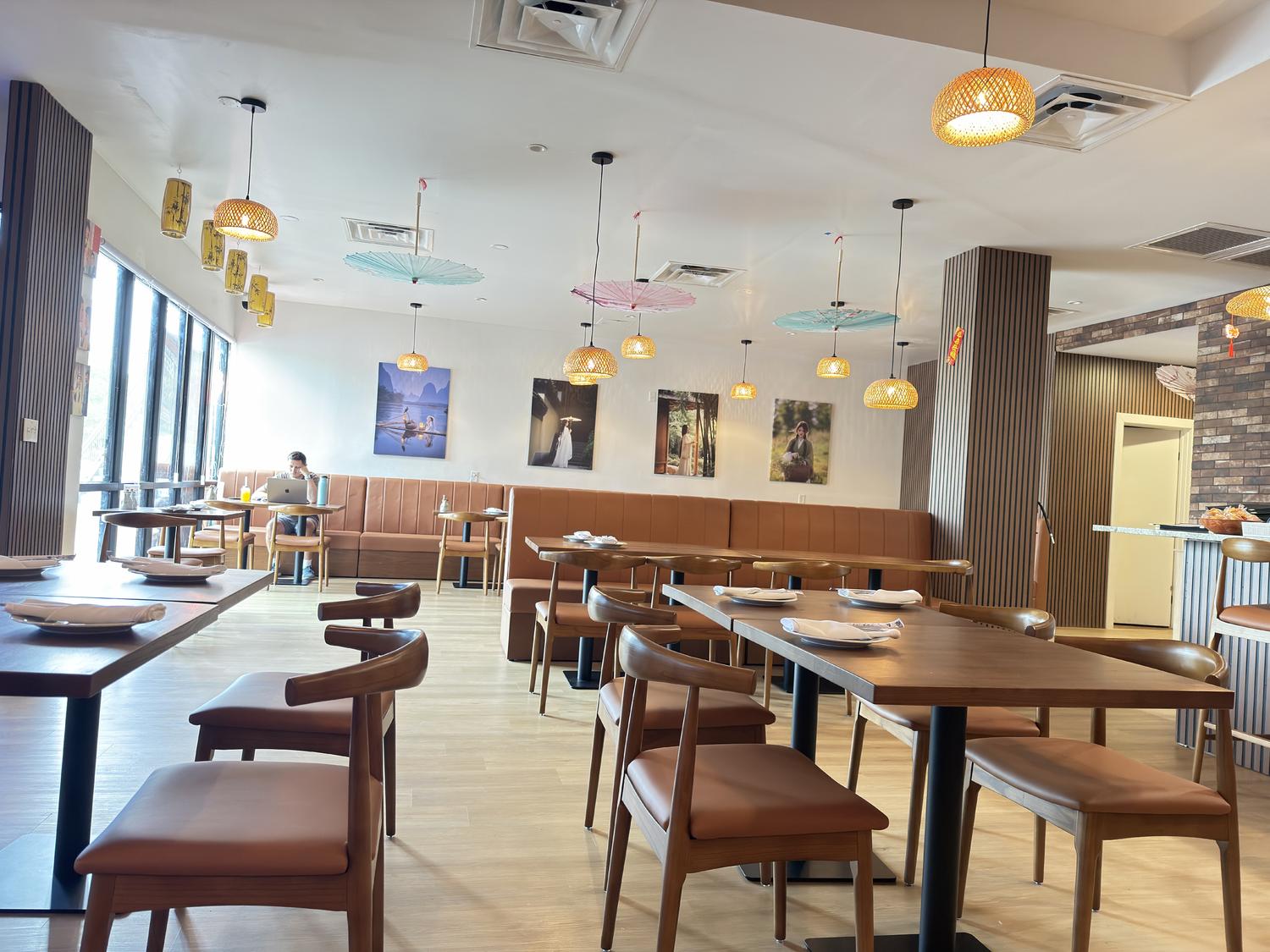 Bright, spacious dining area with booth seating, woven pendant lights, and wall art at SoHo Asian Fusion, a Asian fusion restaurant in Austin