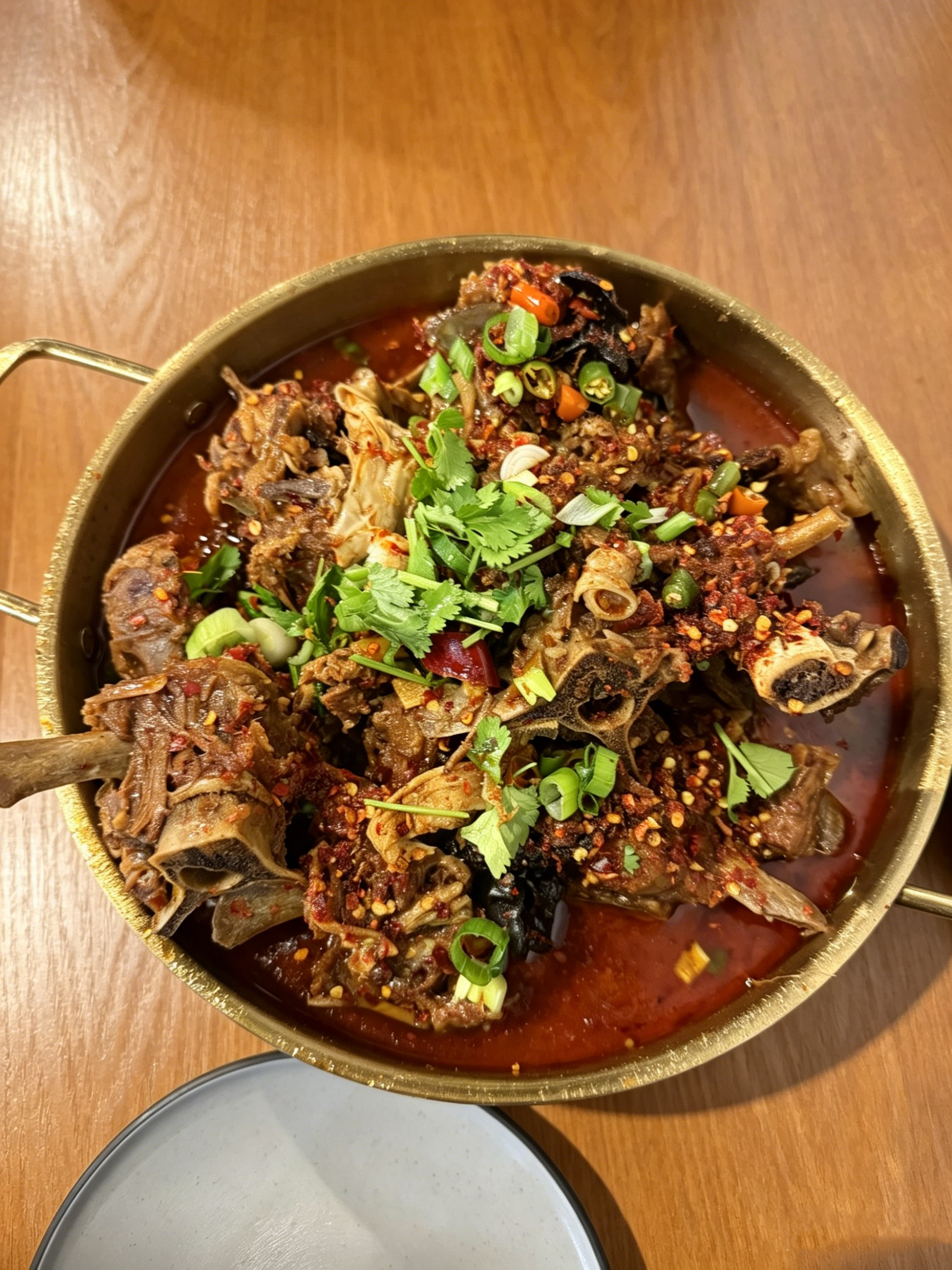 Spicy braised lamb spine hot pot with chili and cilantro at Spice House, a Chinese Restaurant in Plano