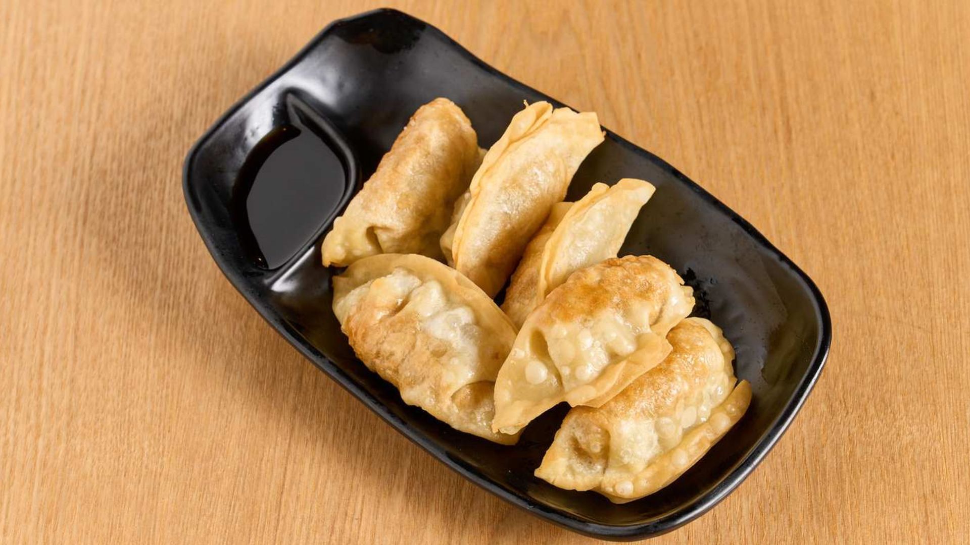 Crispy pan-fried dumplings with soy dipping sauce at Spice House, a Chinese Restaurant in Plano