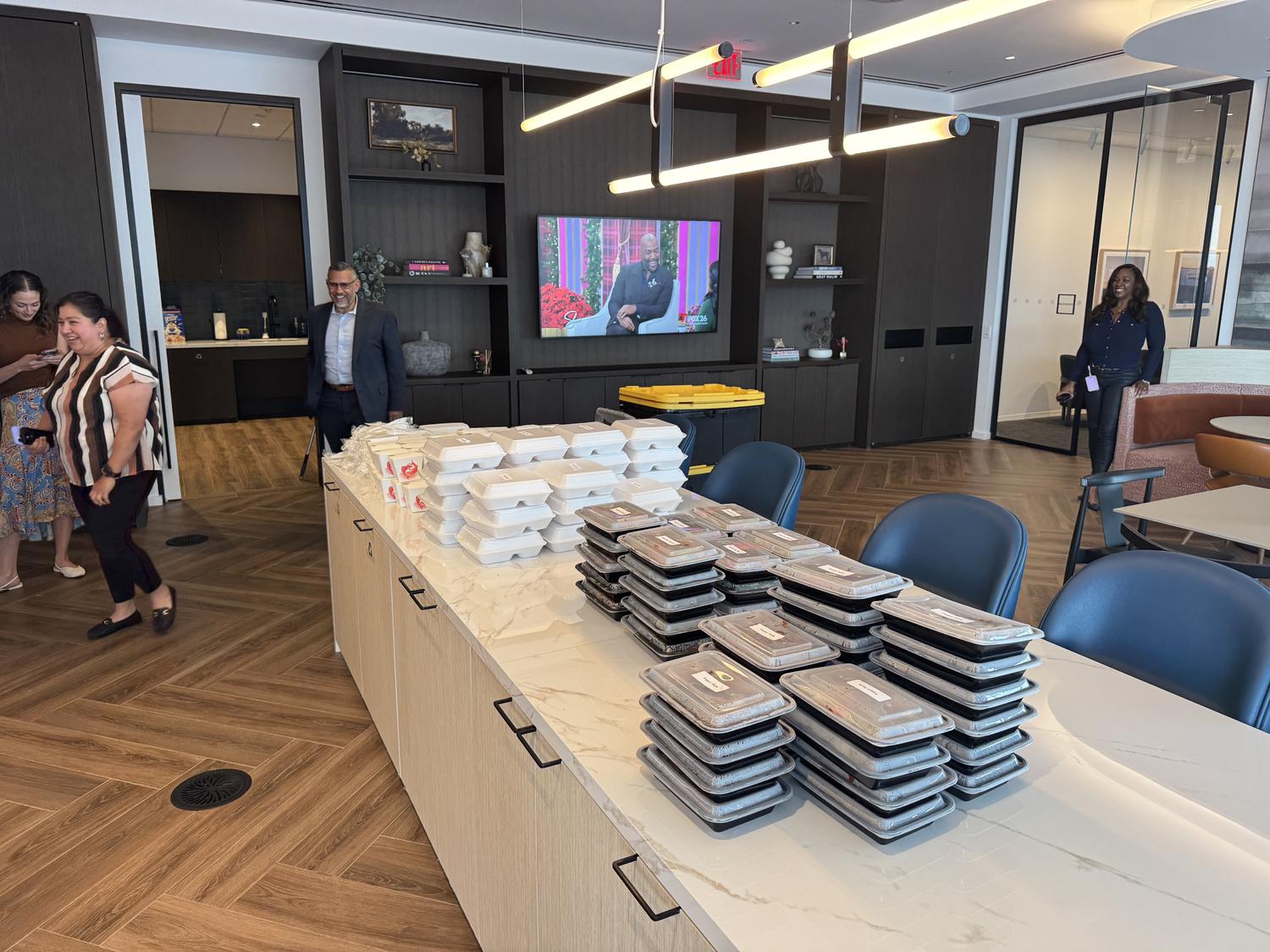 Office catering setup with stacked takeout meal containers on marble counter at Spicy Girl, a Sichuan Restaurant in Houston