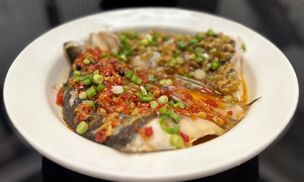 Fish head with spicy chili and savory garlic flavors, garnished with green onions at Spicy Home 那家川菜，a Chinese Restaurant in Hacienda Heights