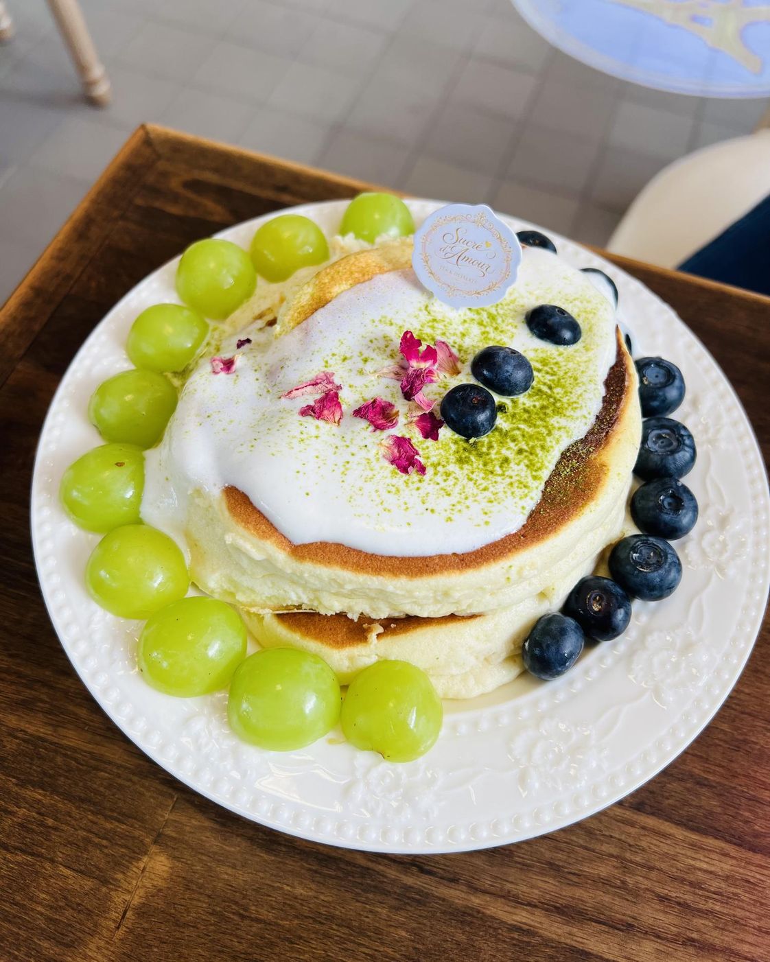Souffle pancake with green grapes, blueberries, cream, and rose petals