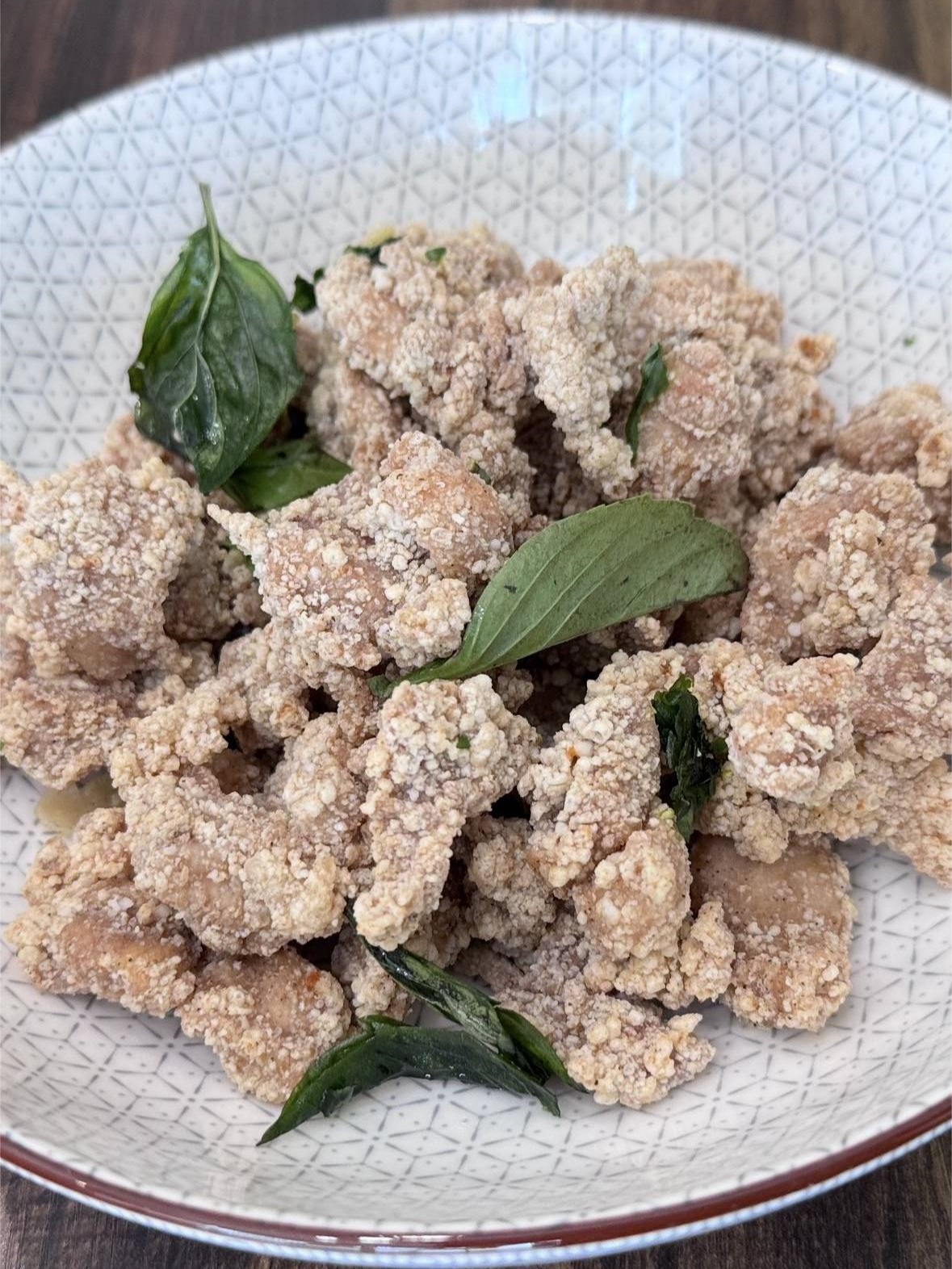 Crispy fried seasoned popcorn chicken garnished with basil leaves at SunLite Eatery，an Asian Fusion Restaurant in Rochester