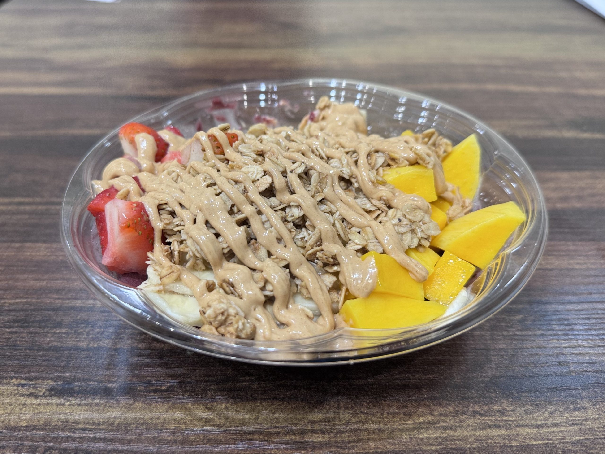 Fresh fruit acai bowl with mango, strawberry, banana and peanut drizzle at SunLite Eatery，an Asian Fusion Restaurant in Rochester