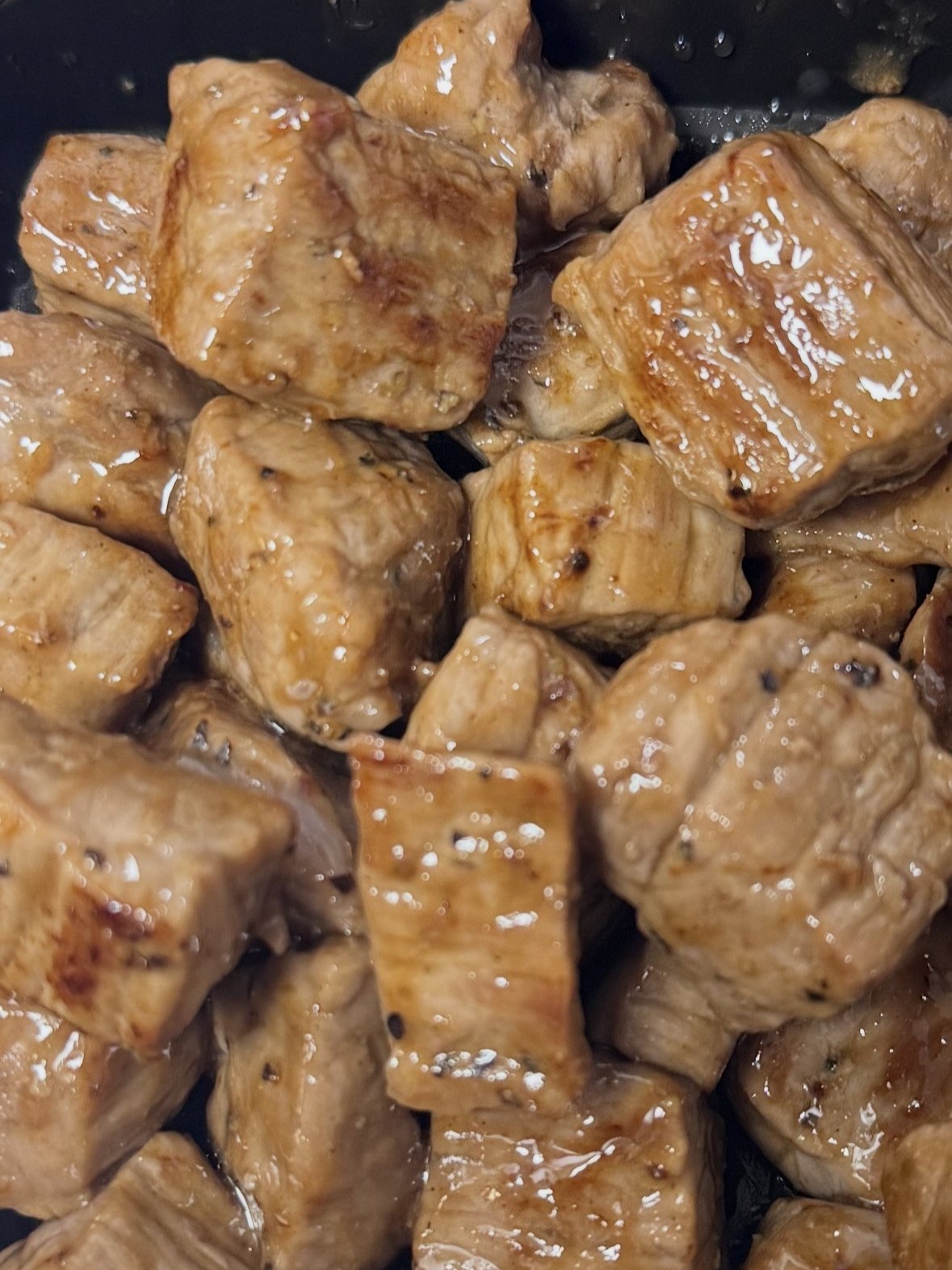 Glossy grilled marinated cubed meat on dark cooking pan at SunLite Eatery，an Asian Fusion Restaurant in Rochester
