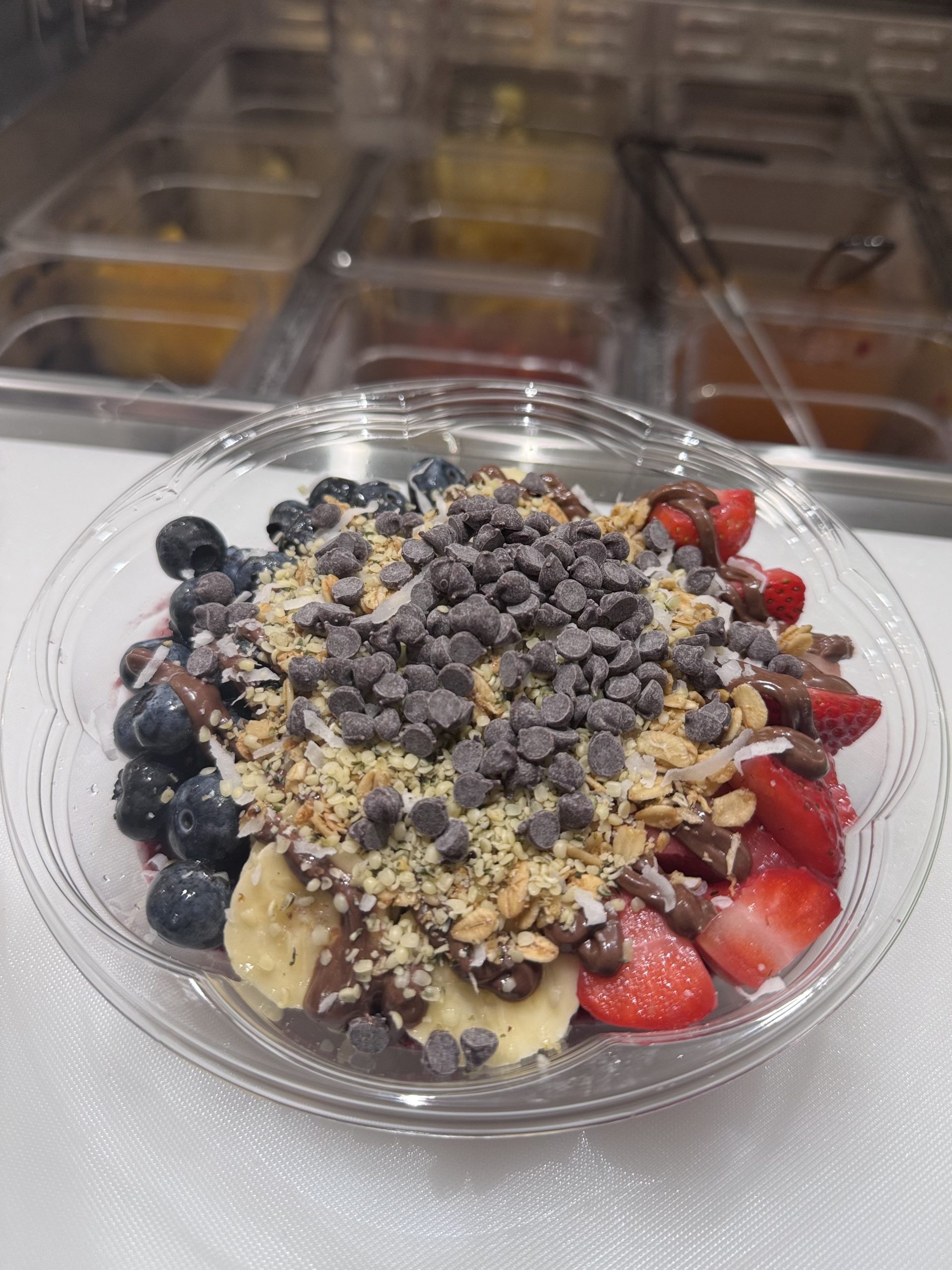Fruit acai bowl topped with berries, banana, granola and chocolate chips at SunLite Eatery，an Asian Fusion Restaurant in Rochester