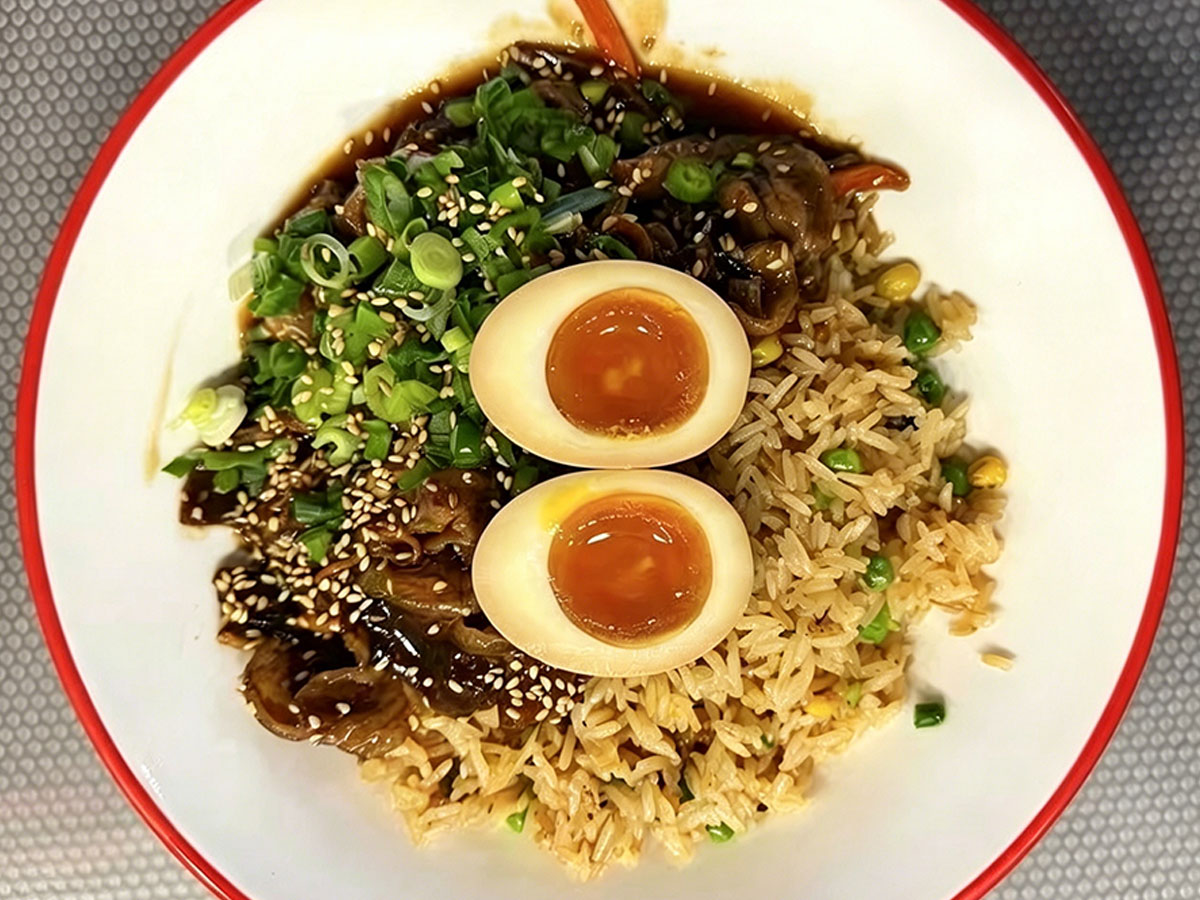 Japanese beef fried rice with soft-boiled egg, green onion, sesame, and peas