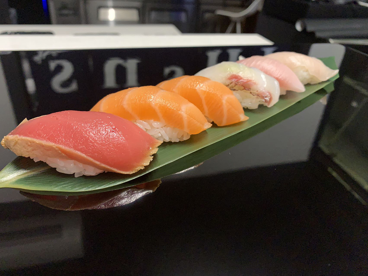 Mixed nigiri sushi assortment served atop a fresh green bamboo leaf at Sushi 295 Mercer, a Sushi restaurant in New York