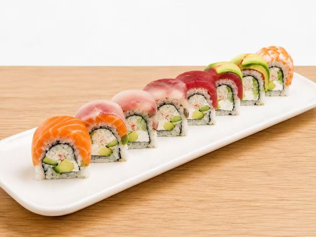 Rainbow sushi roll with assorted fresh fish, avocado and cream cheese filling