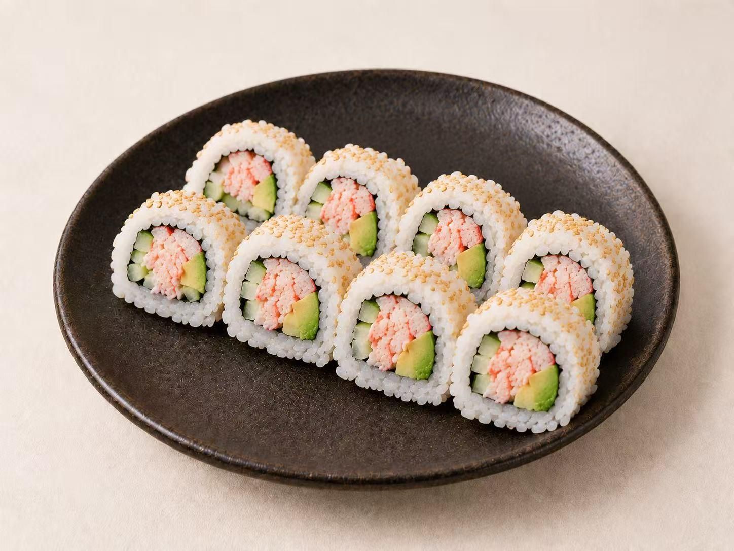 Crab avocado sushi roll with sesame seeds on dark round ceramic plate